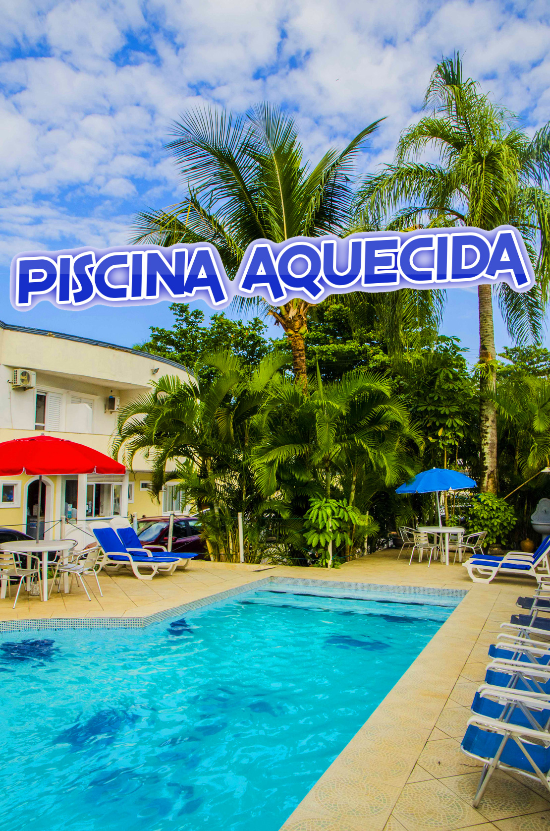 Vista da piscina aquecida, com o céu azul, arecas e coqueiros